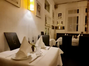 Elegant gedeckter Tisch für zwei Personen mit Speisekarte im gemütlichen Gastraum.